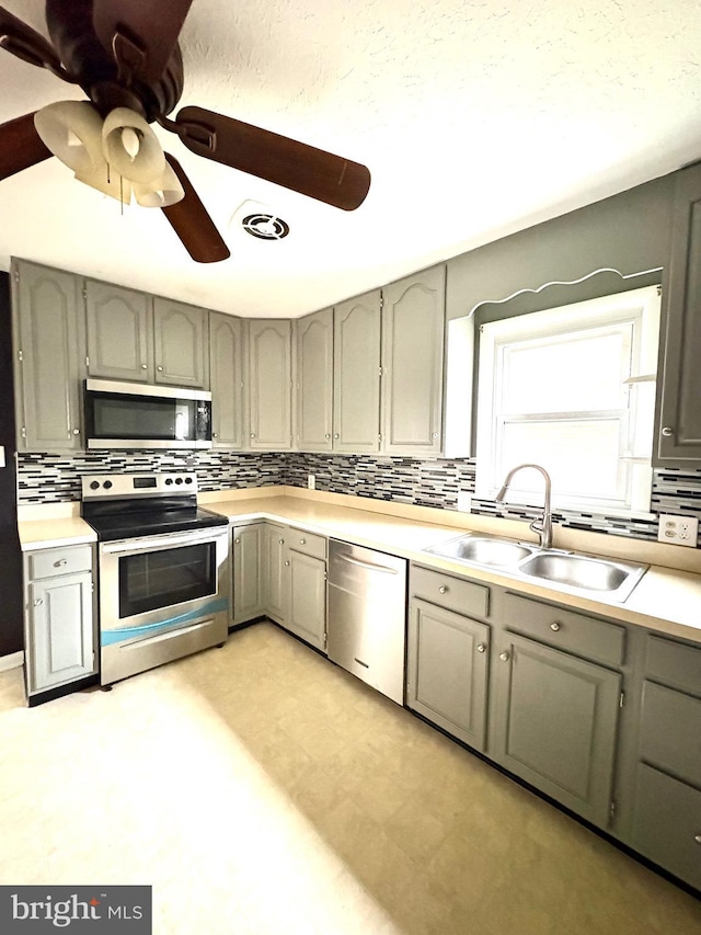 205 Parkway St, Winchester, VA 22601 - kitchen featuring stainless steel appliances, a sink, gray cabinetry, and decorative backsplash