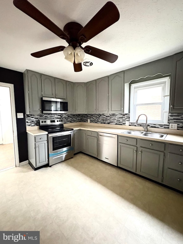 205 Parkway St, Winchester, VA 22601 - kitchen with stainless steel appliances, gray cabinets, a sink, tasteful backsplash, and light countertops