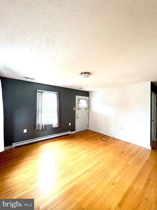 205 Parkway St, Winchester, VA 22601 - unfurnished living room featuring a textured ceiling, light wood finished floors, and baseboard heating