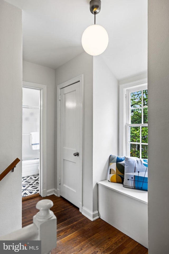 hallway featuring baseboards and wood finished floors