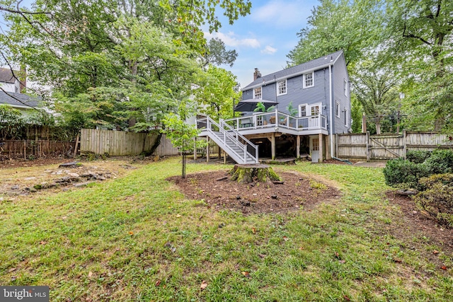 back of house featuring stairway, a wooden deck, a chimney, a yard, and a fenced backyard