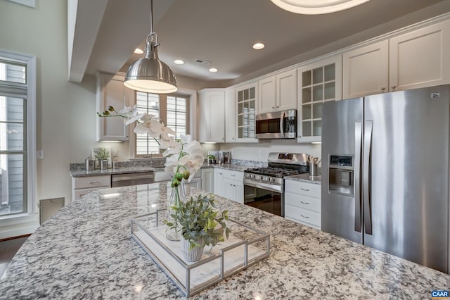 kitchen with white cabinets, glass insert cabinets, and stainless steel appliances