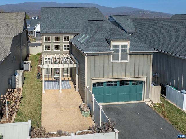 view of front of property featuring a fenced backyard, board and batten siding, and roof with shingles