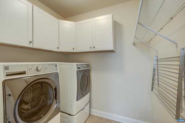 washroom featuring cabinet space, independent washer and dryer, and baseboards