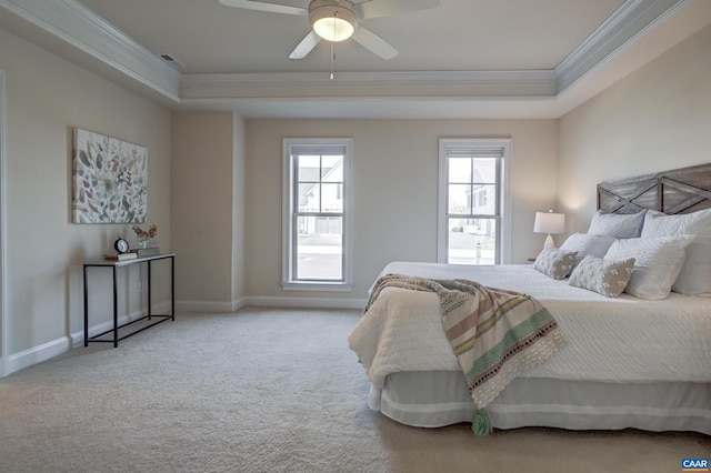 bedroom with a tray ceiling, baseboards, carpet, and crown molding