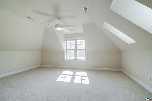 additional living space with visible vents, light colored carpet, and ceiling fan