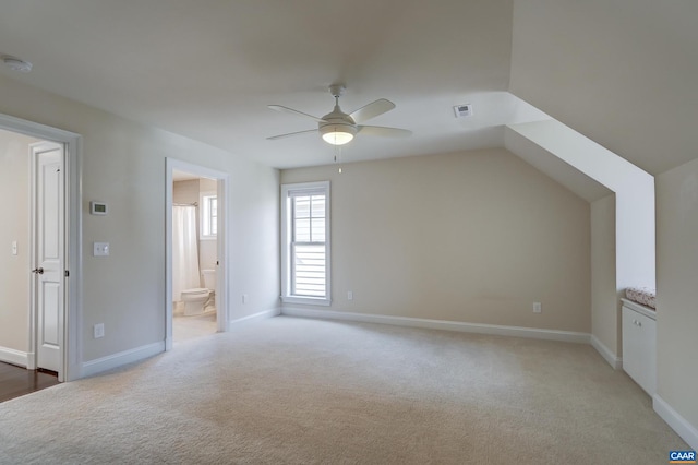 bonus room featuring baseboards, light carpet, visible vents, and a ceiling fan