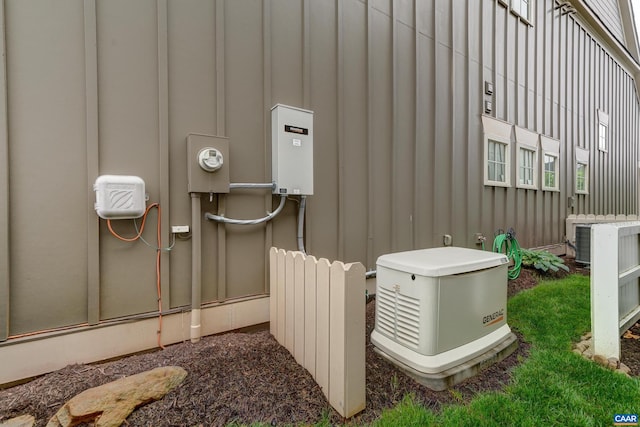 exterior details with electric meter, cooling unit, a power unit, radiator, and board and batten siding