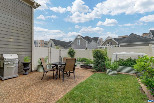 view of yard featuring a residential view, a patio, a vegetable garden, and a fenced backyard