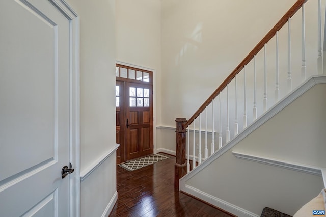entryway with stairway, wood finished floors, and baseboards