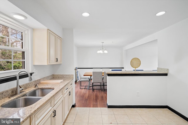 8801 Temple Hill Rd, Clinton, MD 20735 - kitchen featuring light stone countertops, a chandelier, light tile patterned flooring, cream cabinetry, and a sink