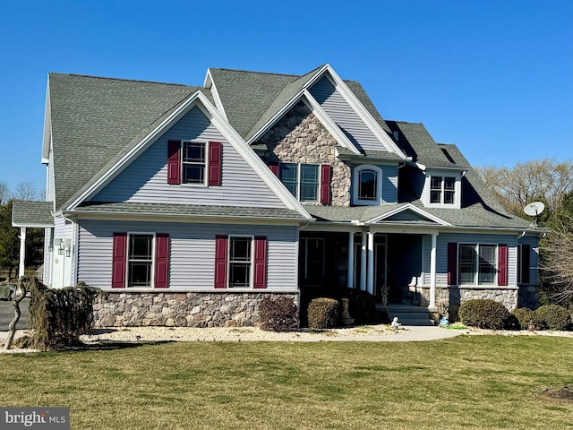 craftsman house featuring a front yard, a porch, and stone siding