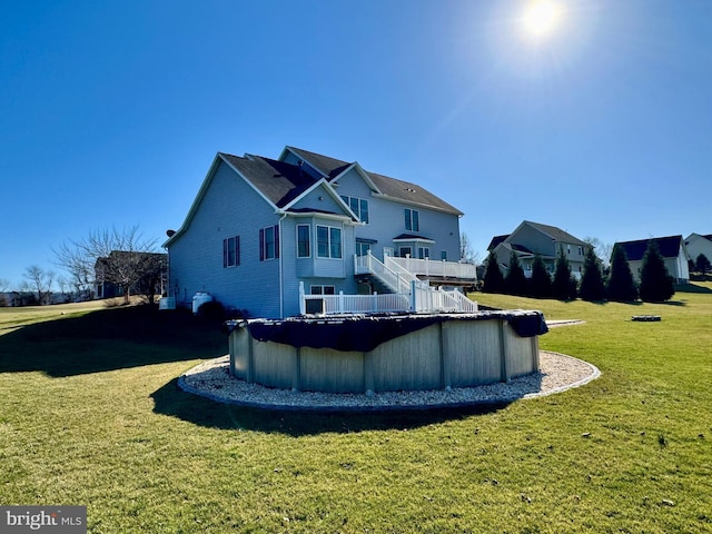 rear view of property with a covered pool and a lawn