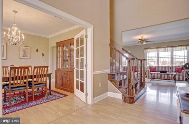dining space with stairs, ornamental molding, and wood finished floors