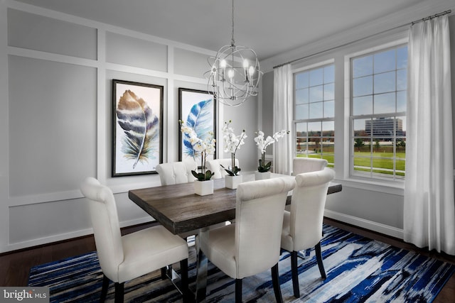 dining room with baseboards, an inviting chandelier, wood finished floors, and a decorative wall