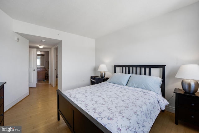 bedroom featuring light wood-style flooring and baseboards