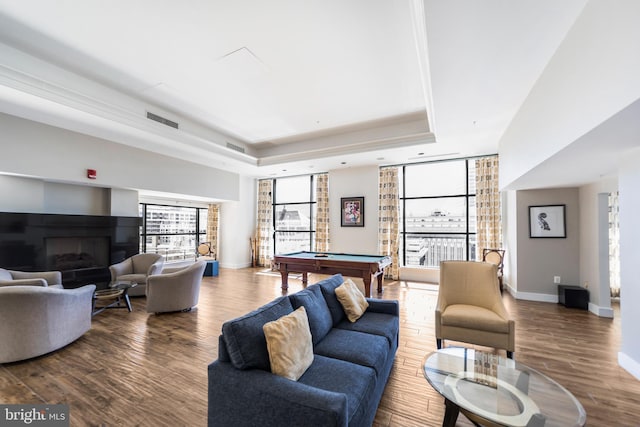 living area featuring visible vents, a fireplace, wood finished floors, a raised ceiling, and billiards