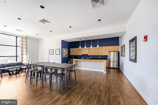 dining space featuring dark wood finished floors, baseboards, and visible vents