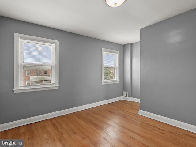 empty room with baseboards and wood finished floors