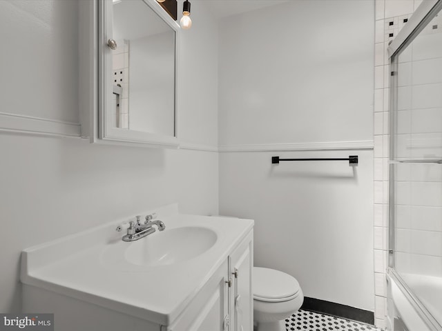 bathroom featuring toilet, vanity, and bath / shower combo with glass door