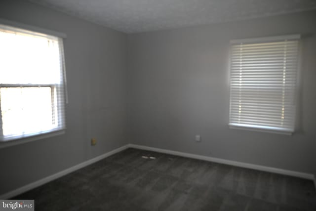 3539 Smokethorn Ct, Waldorf, MD 20602 - empty room featuring a healthy amount of sunlight, baseboards, and dark carpet