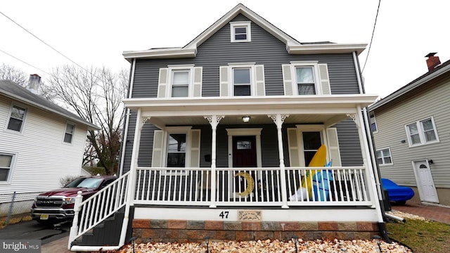 view of front of property featuring a porch and fence