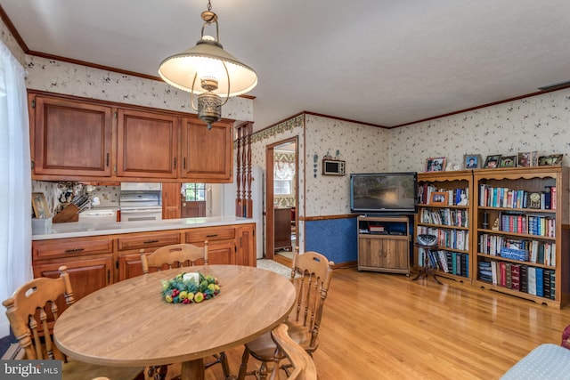 126 Armstrong Pl, Winchester, VA 22602 - dining space with light wood finished floors, visible vents, wallpapered walls, and ornamental molding