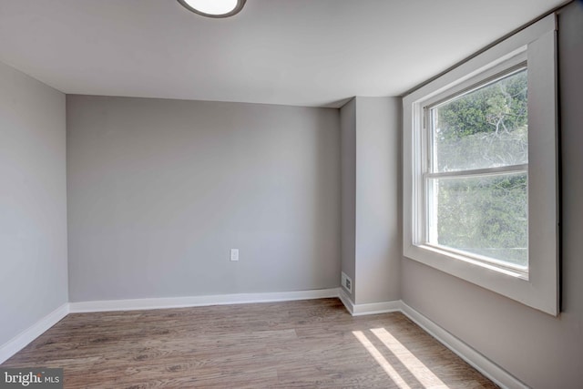 1843 W Pratt St, Baltimore, MD 21223 - empty room with plenty of natural light, wood finished floors, and baseboards