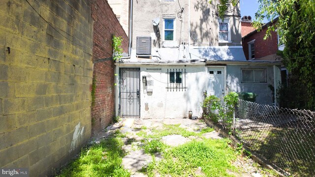 1843 W Pratt St, Baltimore, MD 21223 - back of property featuring fence, stucco siding, and central air condition unit