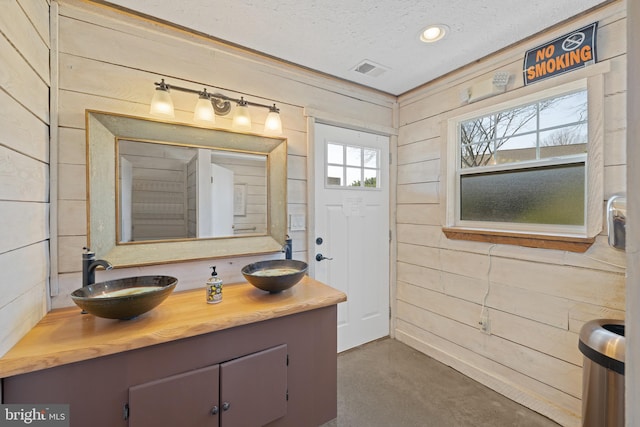 4204 Old Fincastle Rd, Fincastle, VA 24090 - bathroom with finished concrete floors, a textured ceiling, wood walls, and a sink