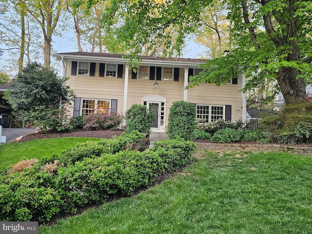 colonial home featuring a front lawn