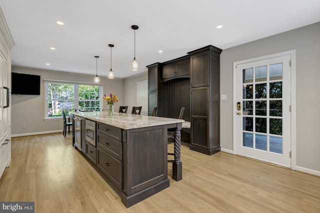 3313 Midland Rd, Fairfax, VA 22031 - kitchen featuring dark brown cabinetry, a breakfast bar, light wood finished floors, baseboards, and a kitchen island