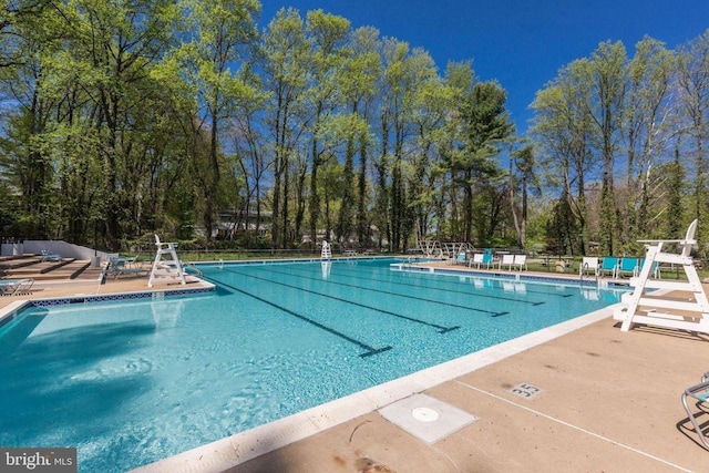 pool featuring fence and a patio area