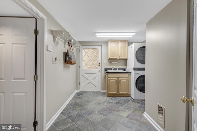 3313 Midland Rd, Fairfax, VA 22031 - washroom with stone finish floor, visible vents, cabinet space, stacked washing maching and dryer, and baseboards