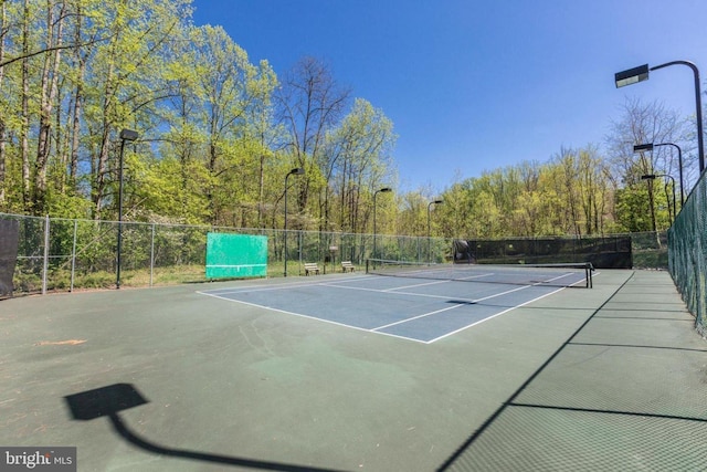 view of tennis court featuring fence