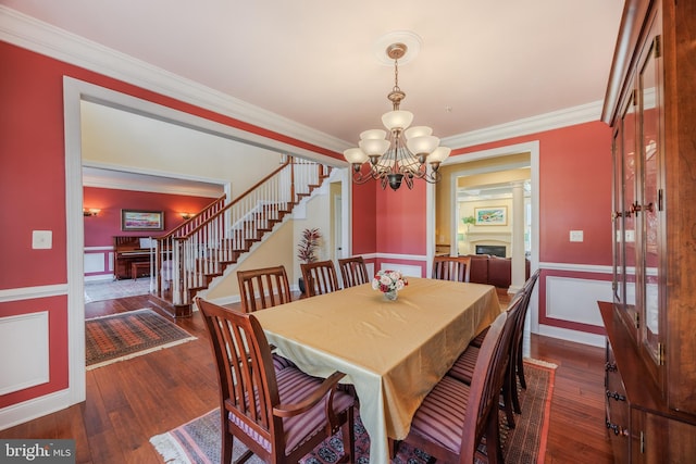 14926 Victory Ln, Glenelg, MD 21737 - dining space featuring a notable chandelier, crown molding, hardwood / wood-style flooring, and a fireplace