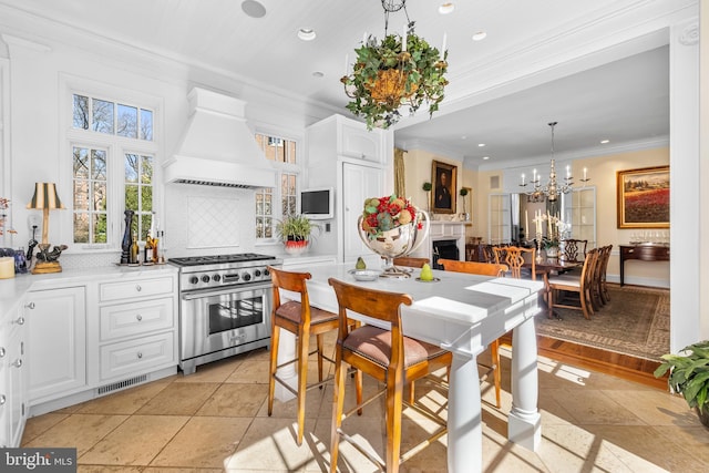 24 Whitfield Rd, Baltimore, MD 21210 - kitchen featuring custom range hood, backsplash, stainless steel stove, crown molding, and white cabinets