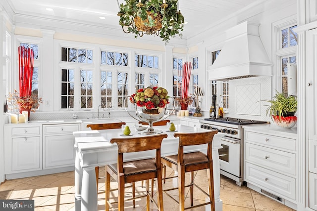 24 Whitfield Rd, Baltimore, MD 21210 - kitchen featuring visible vents, custom exhaust hood, ornamental molding, decorative backsplash, and gas range