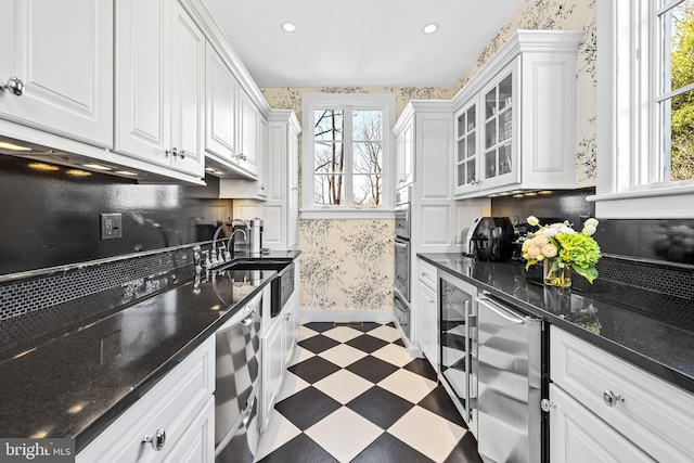 24 Whitfield Rd, Baltimore, MD 21210 - kitchen with wallpapered walls, dark floors, a wealth of natural light, white cabinets, and a sink