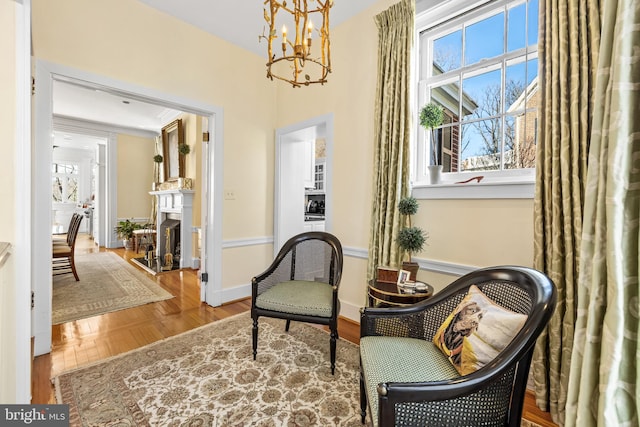 24 Whitfield Rd, Baltimore, MD 21210 - living area featuring baseboards, an inviting chandelier, wood finished floors, and a fireplace