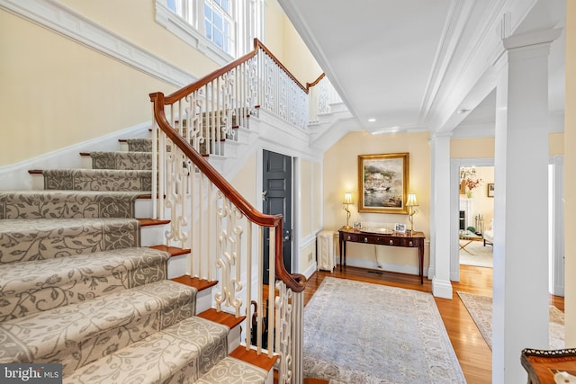 24 Whitfield Rd, Baltimore, MD 21210 - stairs featuring decorative columns, wood finished floors, and ornamental molding