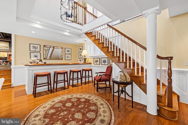 24 Whitfield Rd, Baltimore, MD 21210 - interior space featuring a bar, wood finished floors, a wainscoted wall, and ornate columns