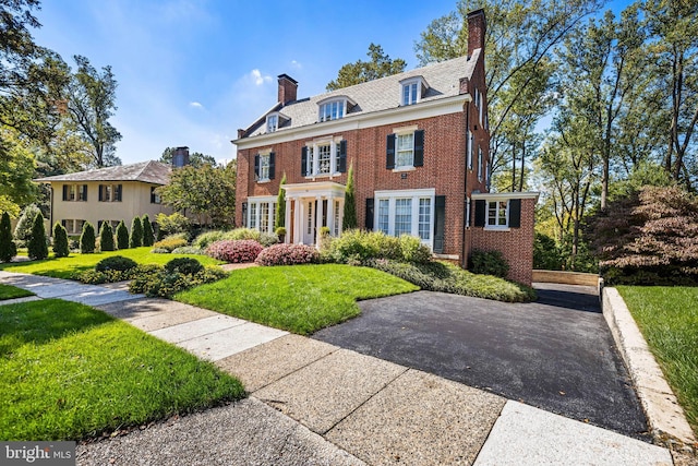 24 Whitfield Rd, Baltimore, MD 21210 - colonial-style house featuring brick siding, a chimney, and a front lawn