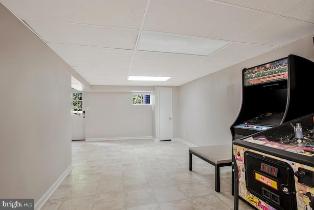 game room with a paneled ceiling and baseboards