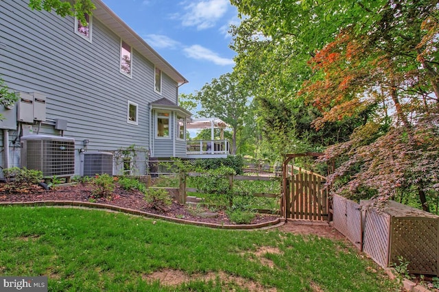 view of yard featuring central AC, a gate, and fence