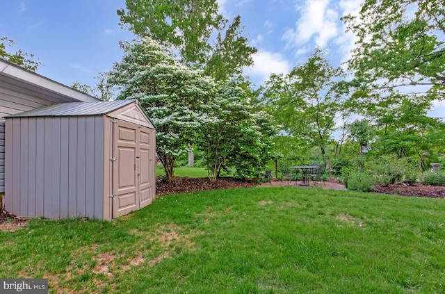 view of grassy yard with a storage shed and an outbuilding