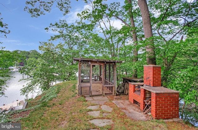 view of yard featuring a water view and exterior structure