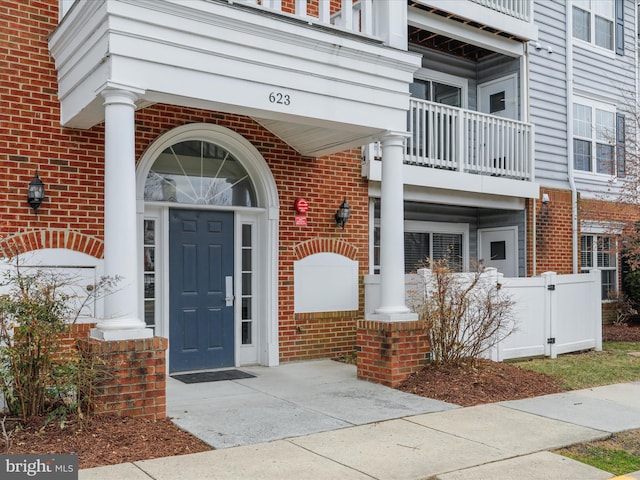 doorway to property with brick siding and a balcony