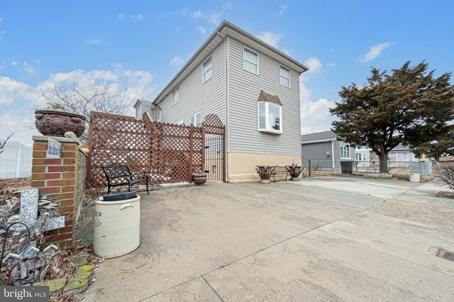 view of side of home with a gate and fence
