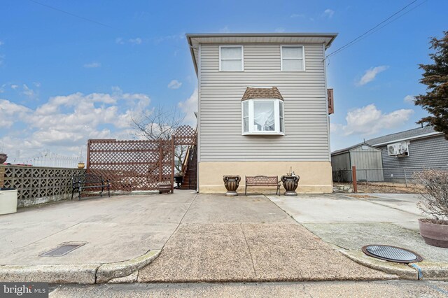 back of property with fence and a patio area